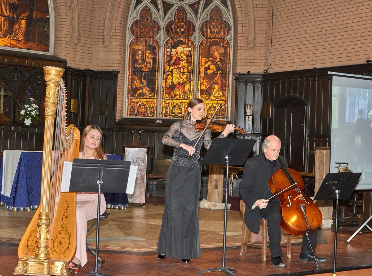 Performance in church with harp, violin, and cello