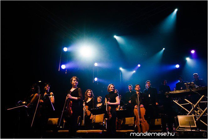 Omega50 Orsi is playing in an orchestra on stage at the Omega50 tour.